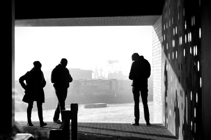 Glasfront mit Ausblick in der Elbphilharmonie Hamburg im Gegenlicht mit Personen