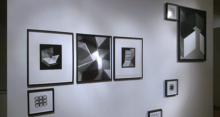 weiße Wand mit quadratischenFotos nebeneinander und kleineren bunt verteilt