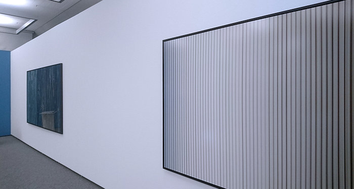 zwei großformatige, abstrakte Fotografien hänger an einer weißen Wand