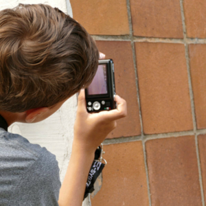 Kind fotografiert Kacheln an Hochhaus